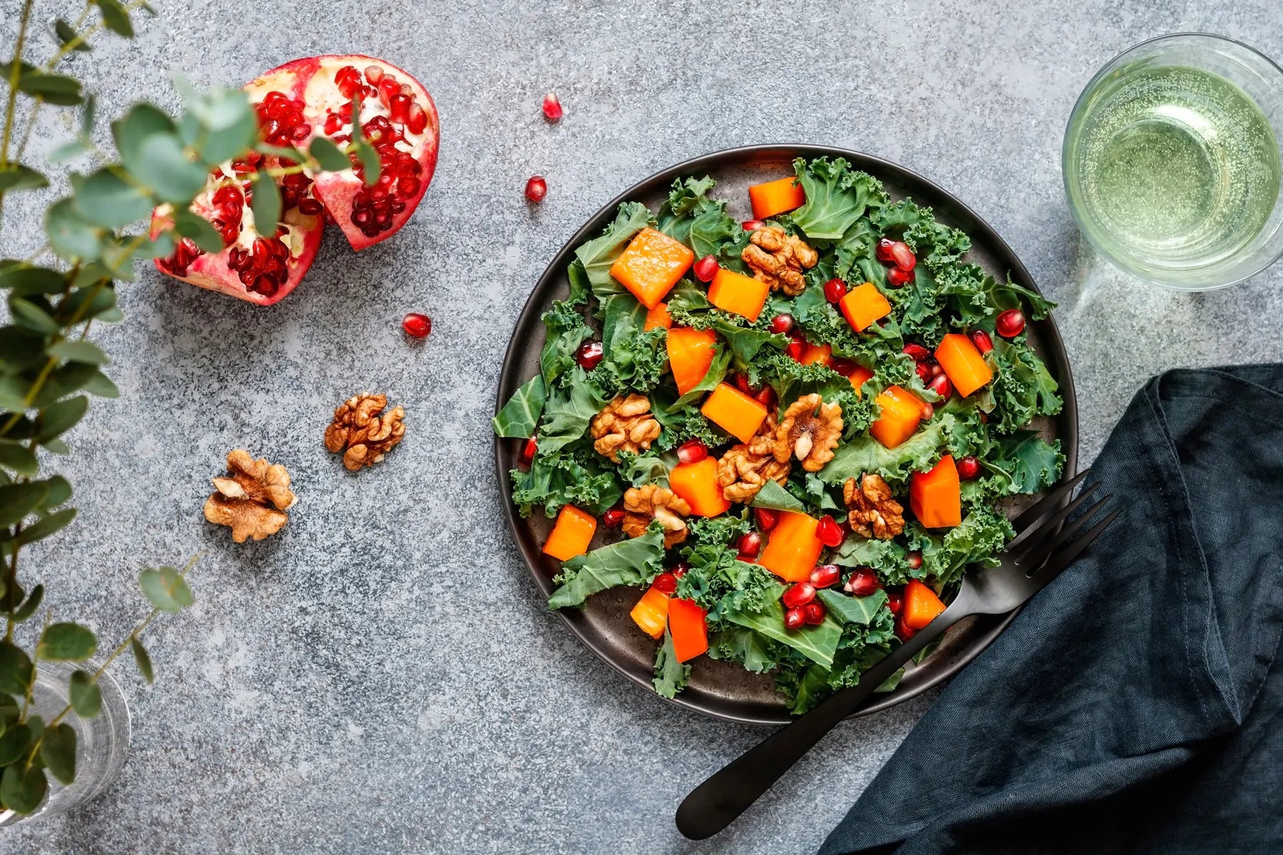 Bowl with kale salad, topped with pumpkin and pomegranate seeds