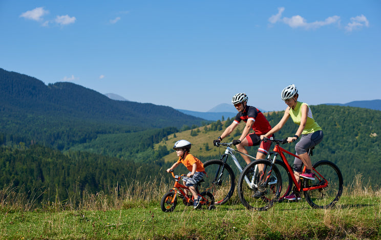 family biking by hills