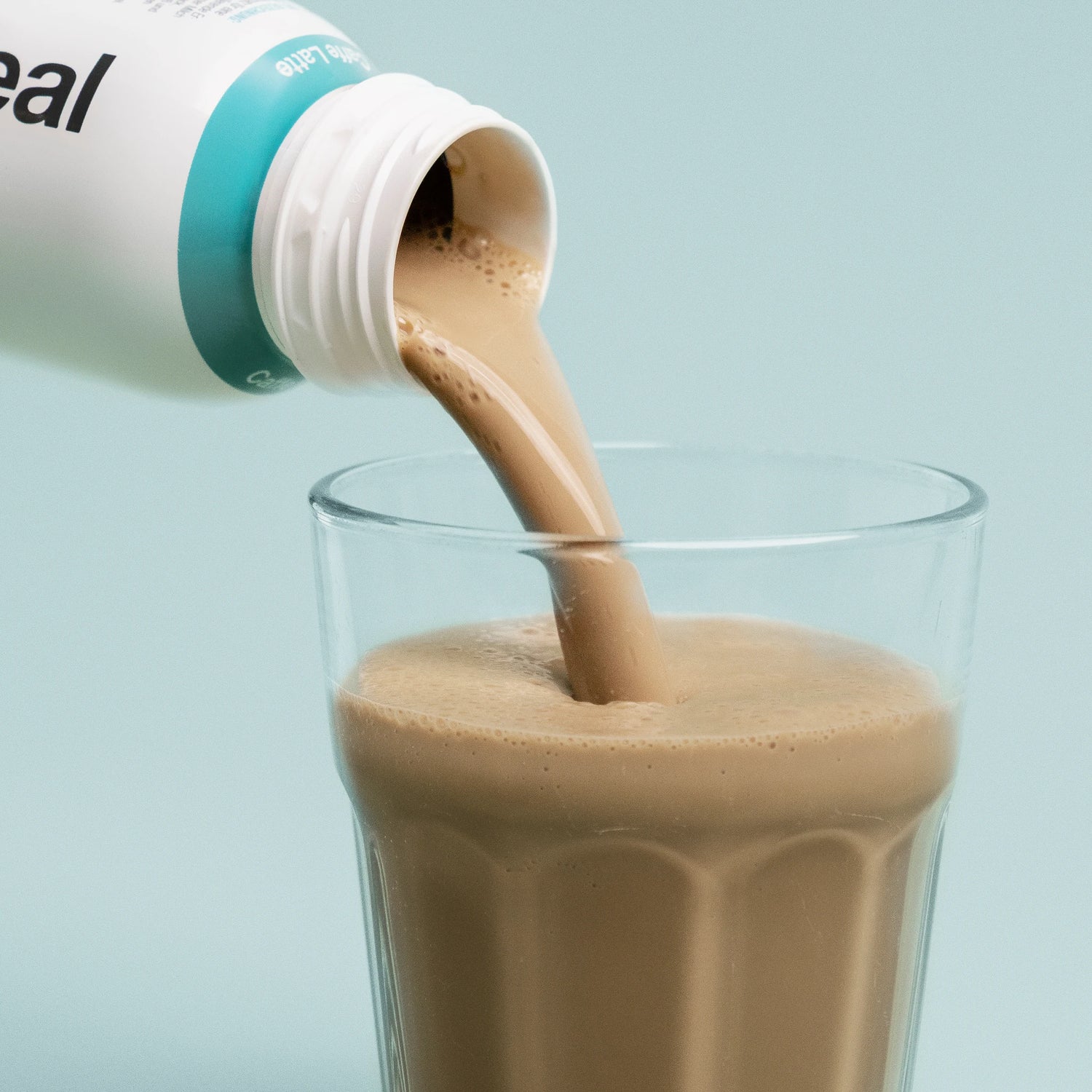 Pouring Nupo One Meal RTD Caffe Latte shake into glass